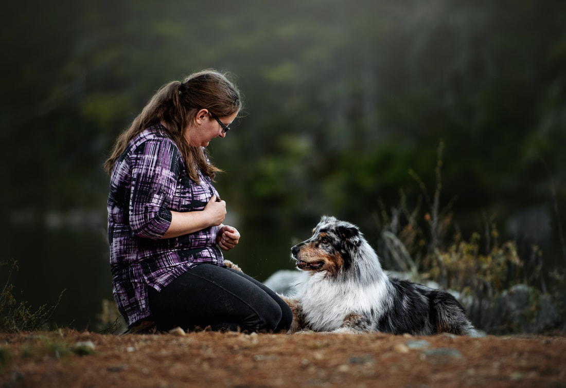 An owner and her Australian Shepherd sharing a quiet moment outdoors
